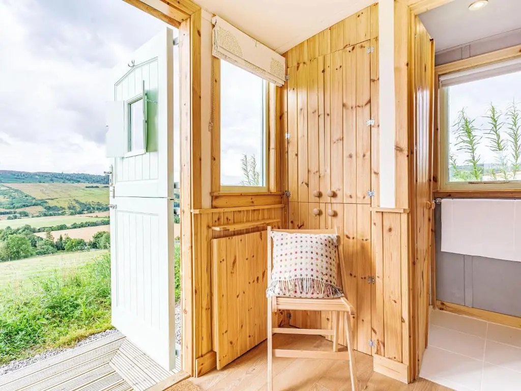 a wooden room with a chair and a window at Woodside Hut 2 - Uk36106 in Auchterneed