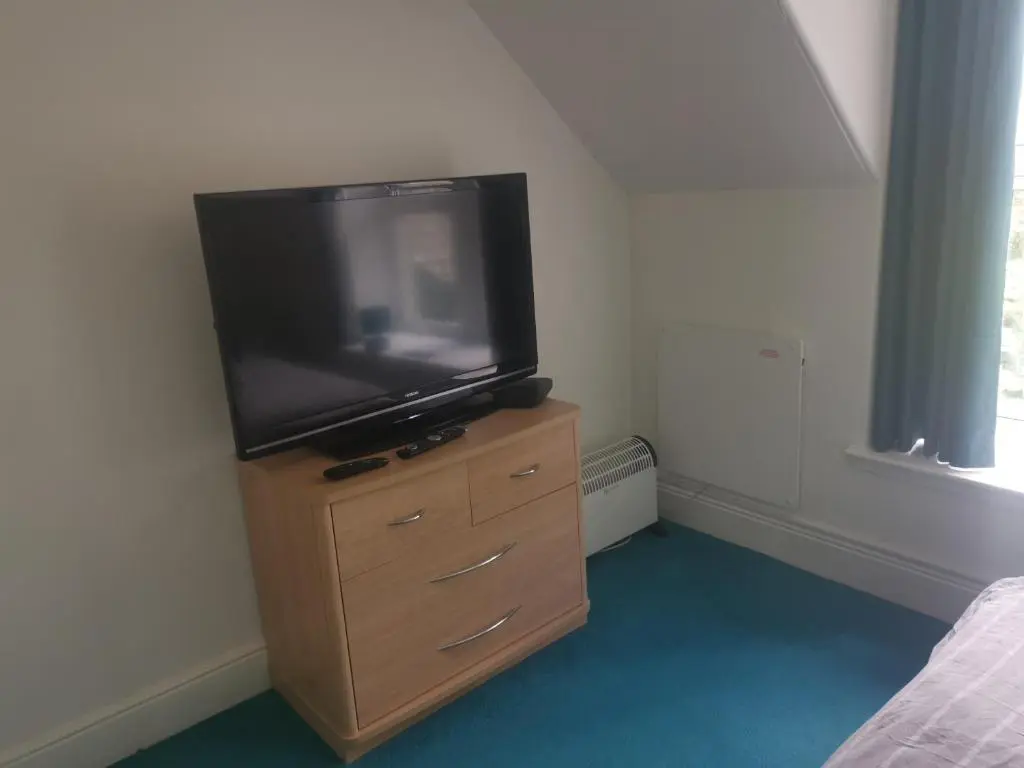 a television sitting on a dresser in a bedroom at Dalwhinnie Old School Hostel in Dalwhinnie