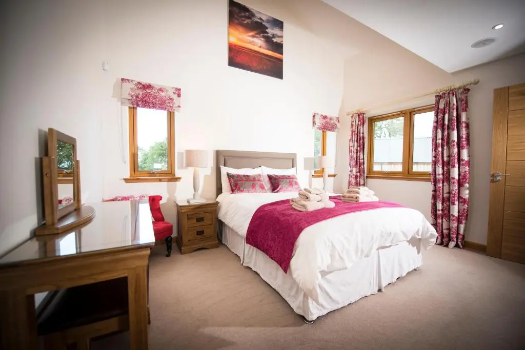 a bedroom with a bed and a desk and windows at Blue Sky Lodges. Atlas & Aurae in Croy