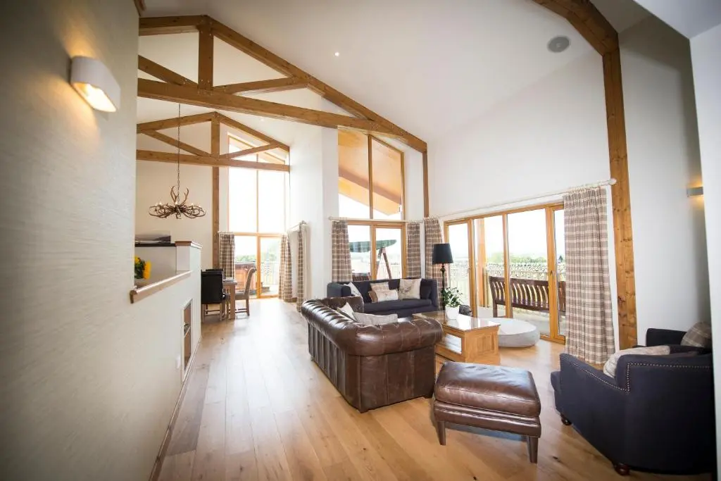 a living room with a leather couch and chairs at Blue Sky Lodges. Atlas & Aurae in Croy