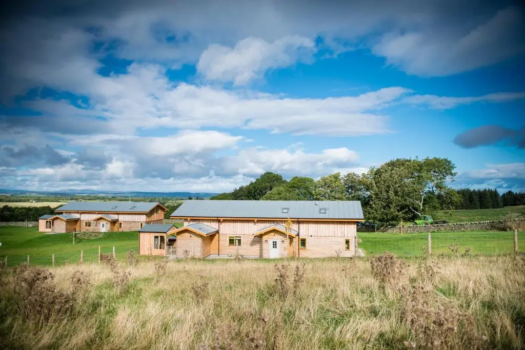 an old farm house in a field with a fence at Blue Sky Lodges. Atlas & Aurae in Croy