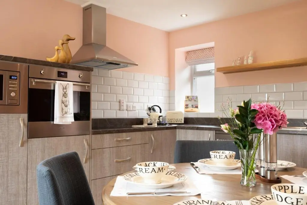 a kitchen with a wooden table with chairs and a dining room at Bramble Cottage in Turriff