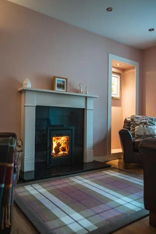 a living room with a fireplace and a couch at Bramble Cottage in Turriff
