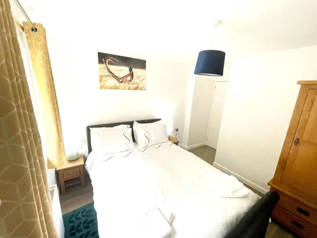 a bedroom with a bed with white sheets and pillows at Matara House Holiday Home in Inverness