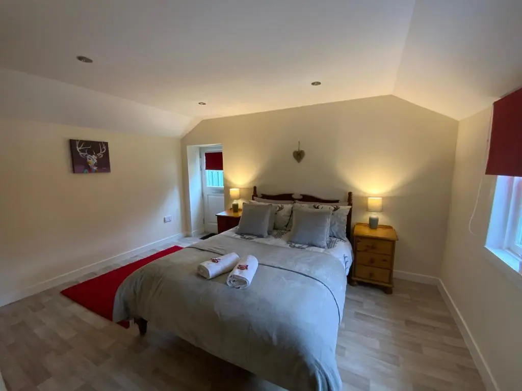 a bedroom with a bed with two towels on it at Deeside Snugs Apartments in Kincardine O\u02bcNeil