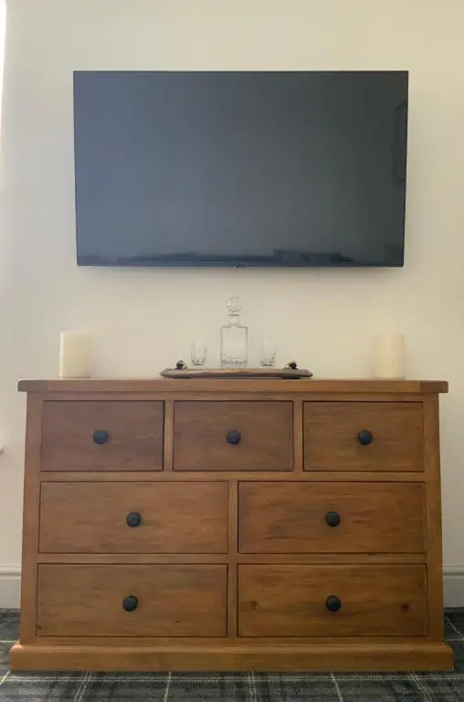 a wooden dresser with a tv on top of it at Deeside Snugs Apartments in Kincardine O\u02bcNeil