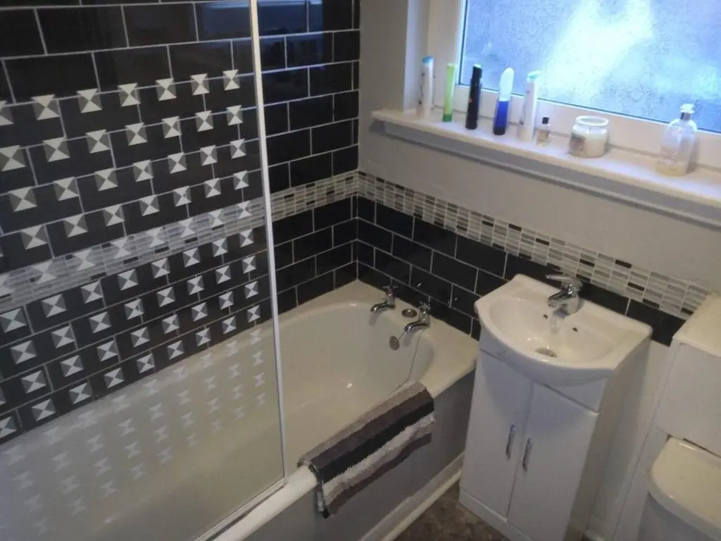 a bathroom with a tub and a sink and a toilet at 3-Bed House Sleeps 5 5 min walk from City Centre in Inverness