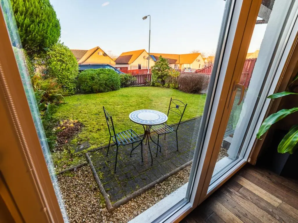 a view of a table and chairs from a window at Willa , Cosy house in Inverness in Inverness