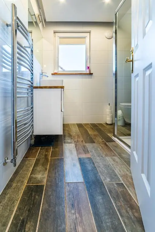 a bathroom with a shower and a wooden floor at Willa , Cosy house in Inverness in Inverness
