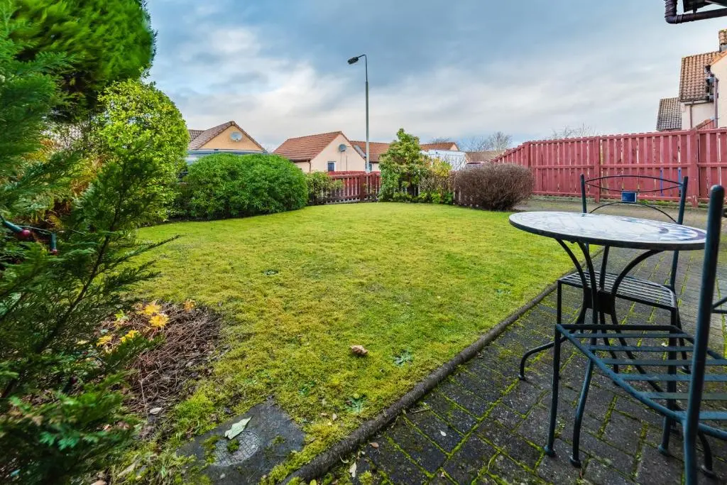 a table and chairs in a yard with a fence at Willa , Cosy house in Inverness in Inverness
