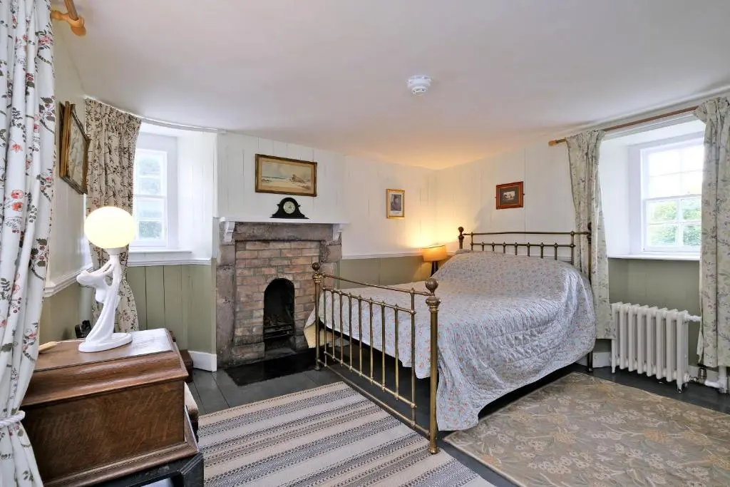 a bedroom with a bed and a fireplace at Lickleyhead Castle in Insch