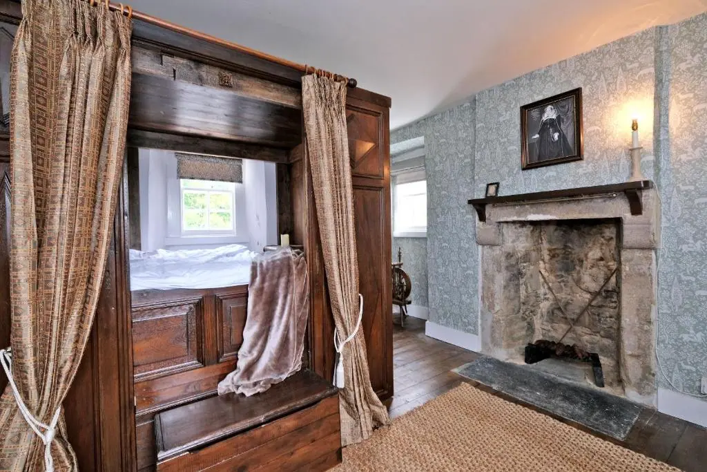 a bedroom with a bed and a fireplace at Lickleyhead Castle in Insch