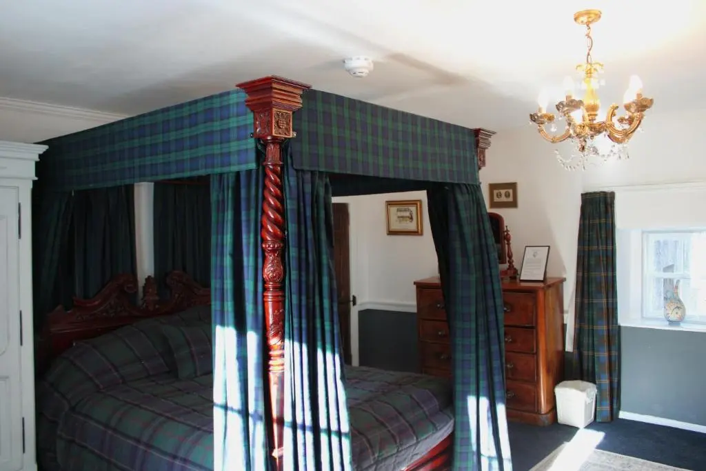 a bedroom with a bed with a canopy at Lickleyhead Castle in Insch
