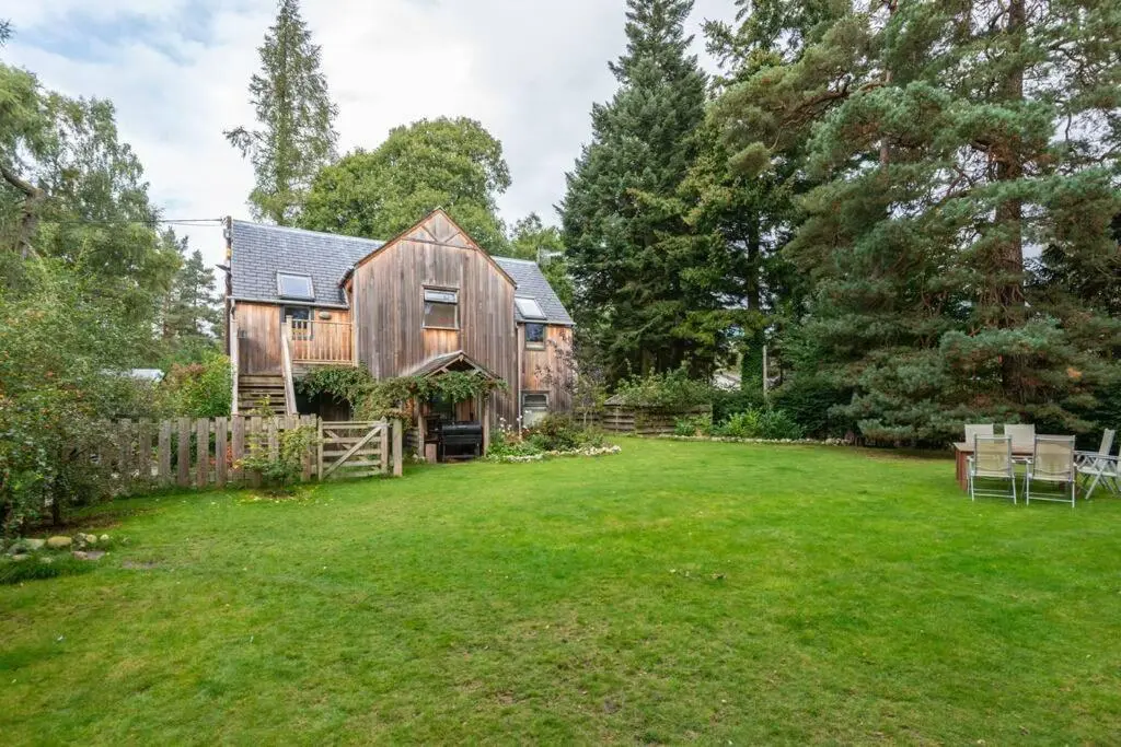 a large yard with a wooden house at The Beeches Studio, Highlands of Scotland in Newtonmore