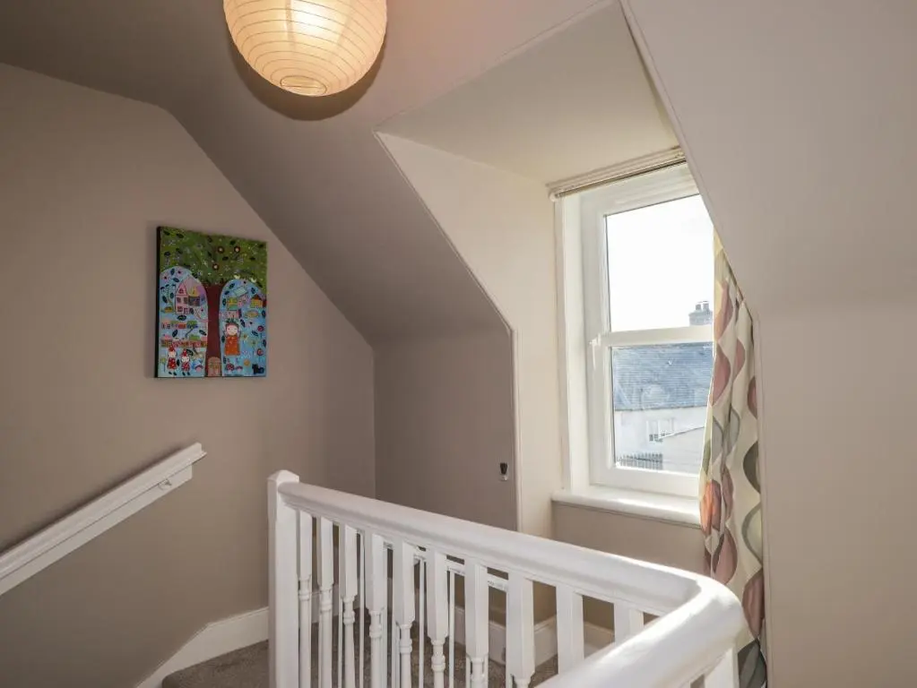 a white staircase with a white crib and a window at 62 Society Street in Nairn