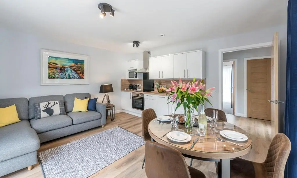 a living room with a table and a couch at High Range Holiday Apartments in Aviemore