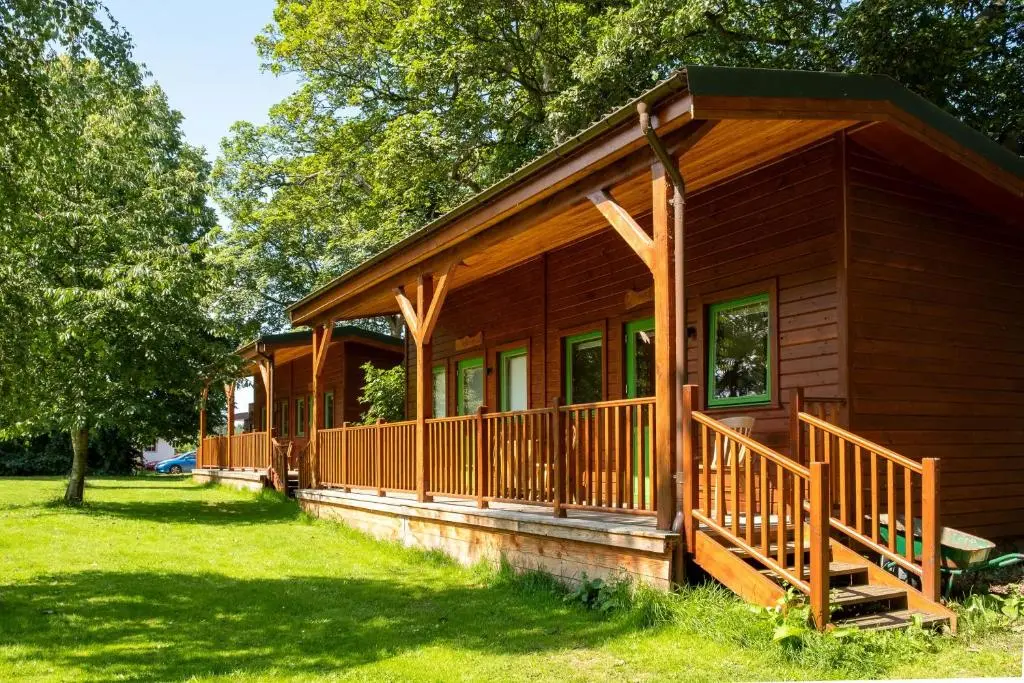a log cabin with a large porch and a deck at Marcassie Farm Lodges - Hazel Studio in Forres