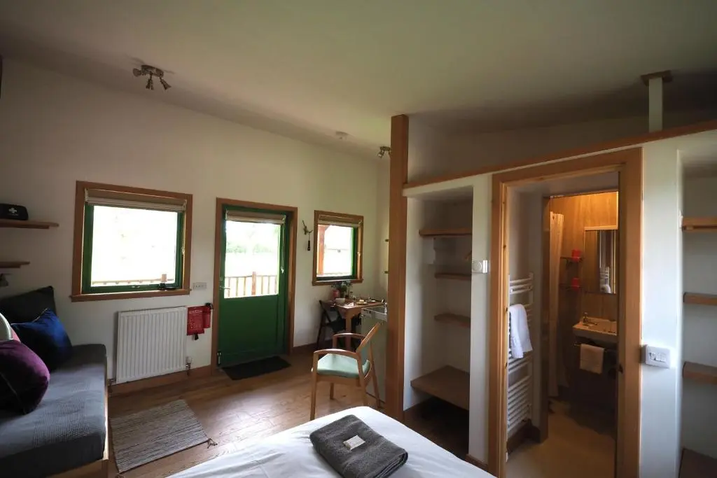 a bedroom with a bed and a living room at Marcassie Farm Lodges - Hazel Studio in Forres