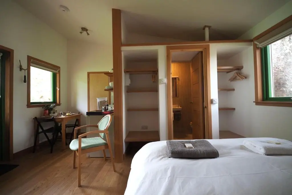 a bedroom with a bed and a desk and a chair at Marcassie Farm Lodges - Hazel Studio in Forres