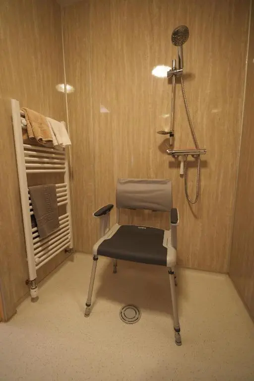 a hospital room with a chair and a shower at Marcassie Farm Lodges - Oak Studio - Accessible in Forres