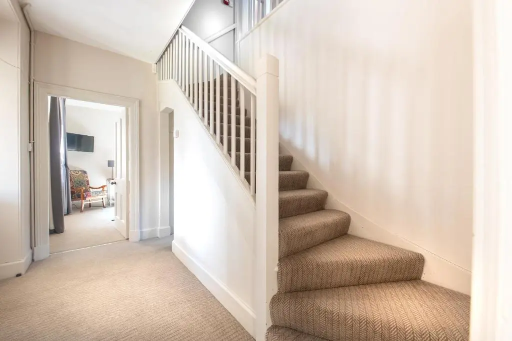 a staircase in a home with white walls at The Cottage, The Loch Ness Cottage Collection in Inverness