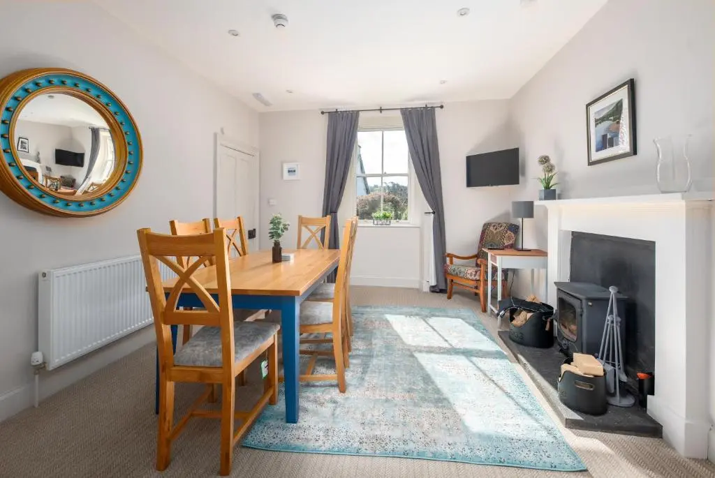 a dining room with a table and chairs and a fireplace at The Cottage, The Loch Ness Cottage Collection in Inverness