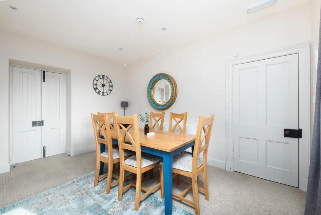 a dining room with a wooden table and chairs at The Cottage, The Loch Ness Cottage Collection in Inverness