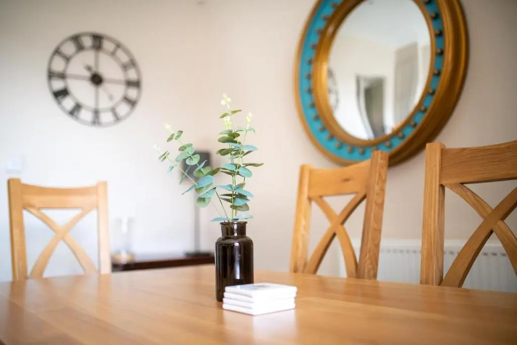 a vase with a plant in it sitting on a table at The Cottage, The Loch Ness Cottage Collection in Inverness
