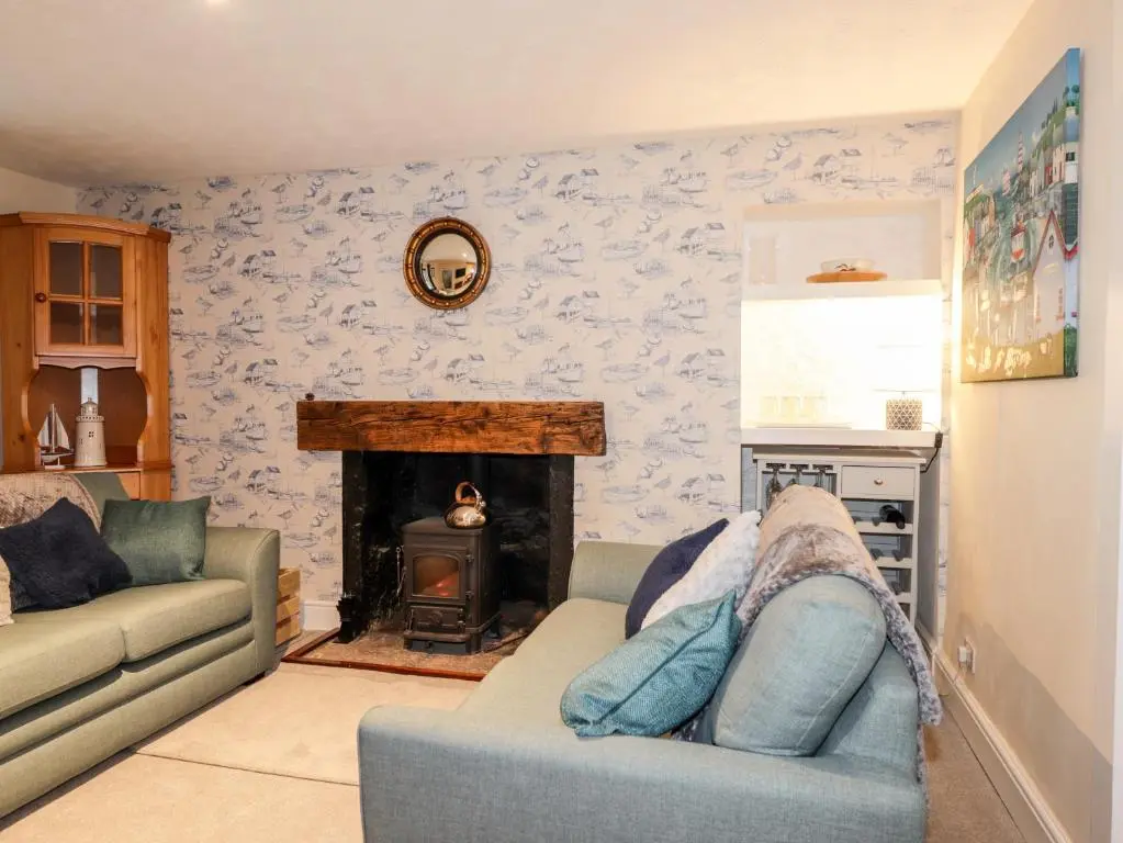 a living room with a couch and a fireplace at Griffin Cottage in Nairn