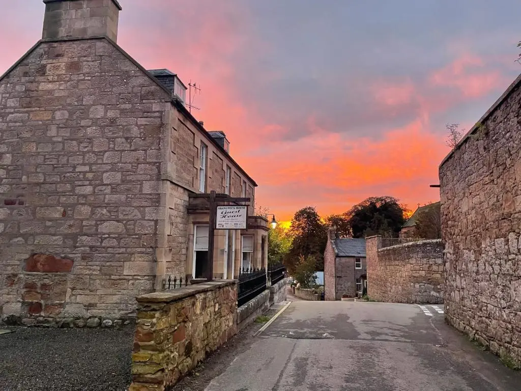an old stone building with a sunset in the background at Shandwick House in Tain