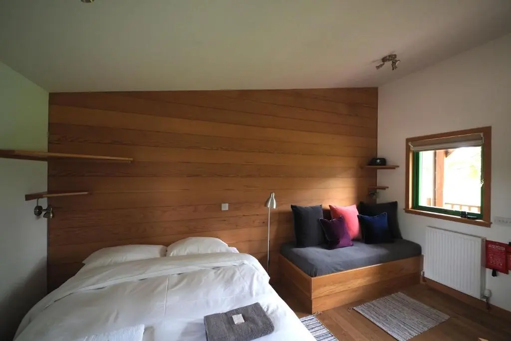 a bedroom with a large bed with a wooden headboard at Marcassie Farm Lodges - Blackthorn Studio in Forres