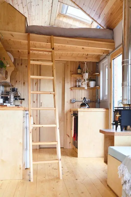 a tiny house with a ladder in a kitchen at Aileen - Unique tiny house with wood fired roll top bath in heart of the Cairngorms in Ballater