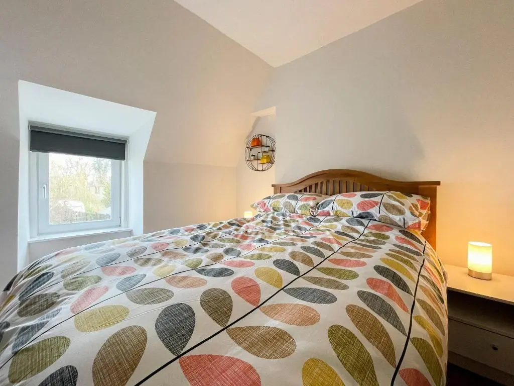 a bedroom with a bed and a window at Academy Street Cottage in Tain