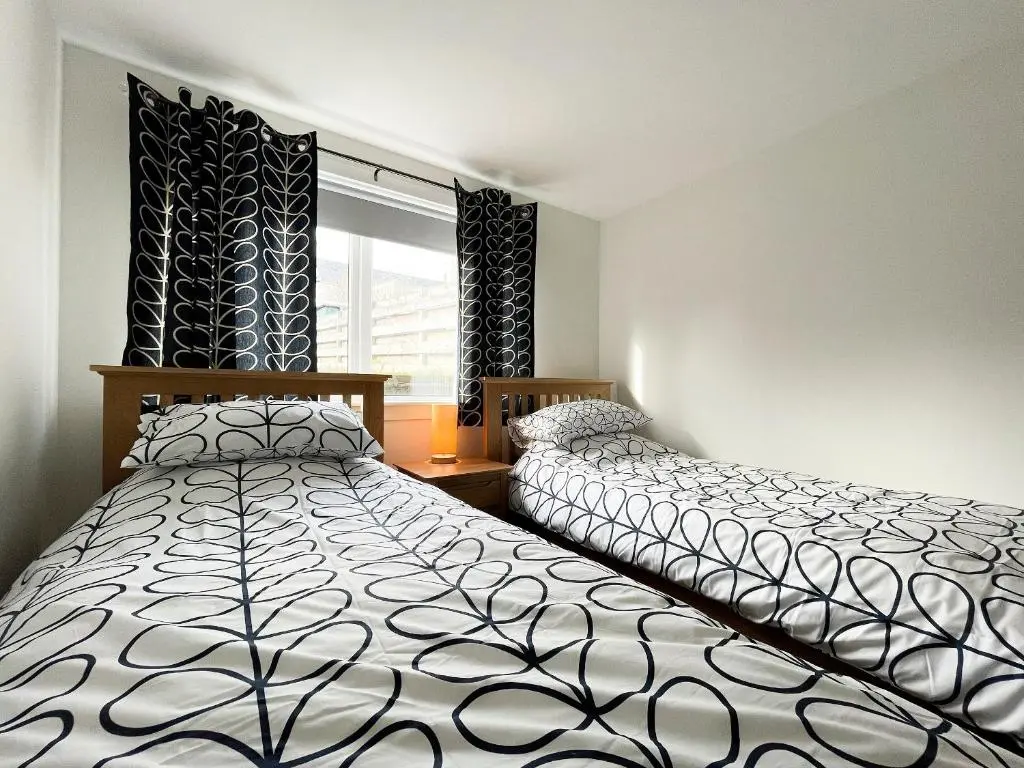 a bedroom with two beds and a window at Academy Street Cottage in Tain