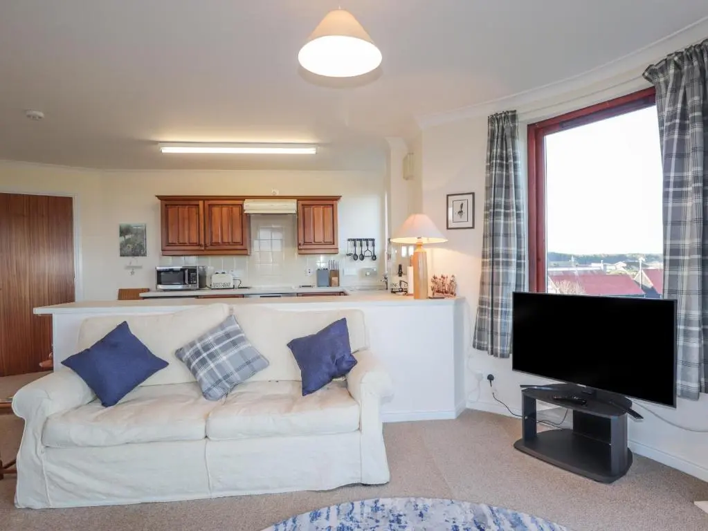 a living room with a couch and a flat screen tv at Aurora View in Forres