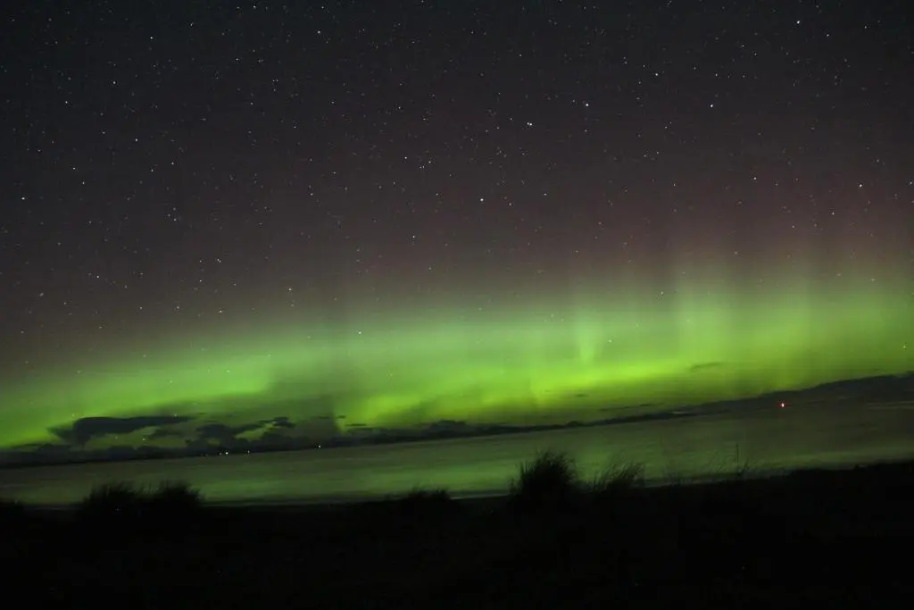 an aurora in the night sky over a field at Aurora View in Forres