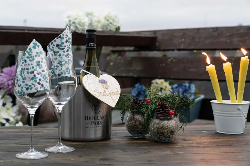 a bottle of wine and two glasses on a table at Dunedin House -Contractors - Business Travellers in Huntly