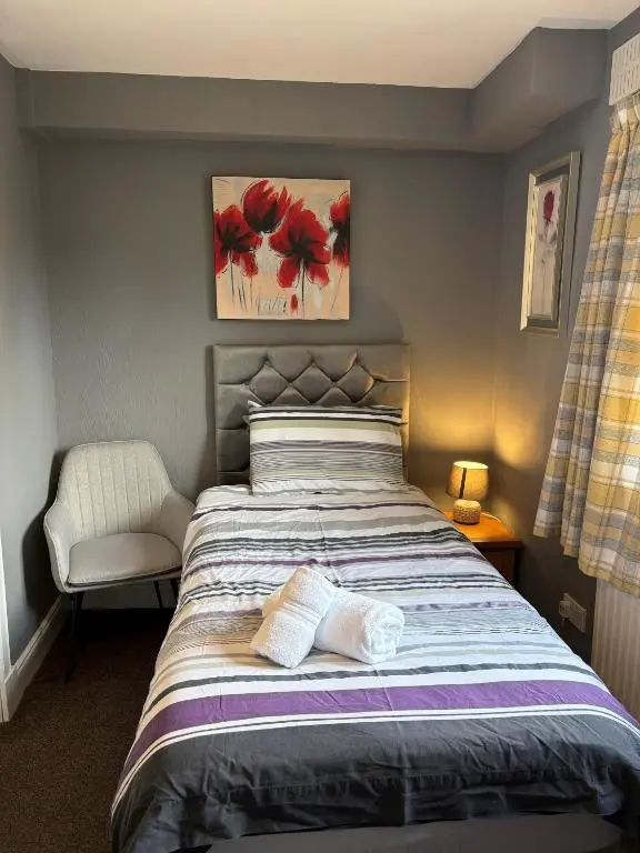 a bedroom with a bed with two towels on it at Winmar in Inverness