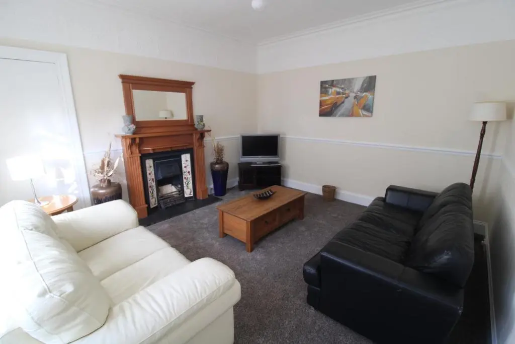 a living room with a white couch and a fireplace at Winmar in Inverness