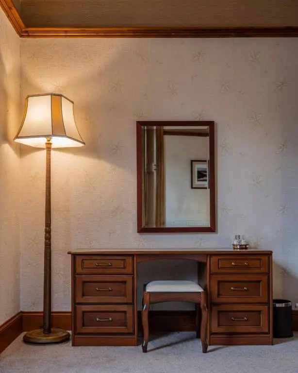 a dressing table with a lamp and a mirror at The Old Bank House Self Catering Apartment Dornoch in Dornoch