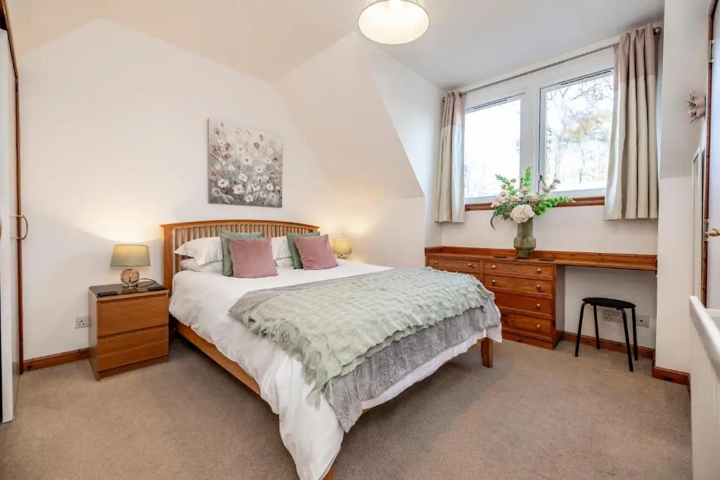 a bedroom with a bed and a dresser and a window at Bright House with Garden & Patio in Market Town in Inverurie