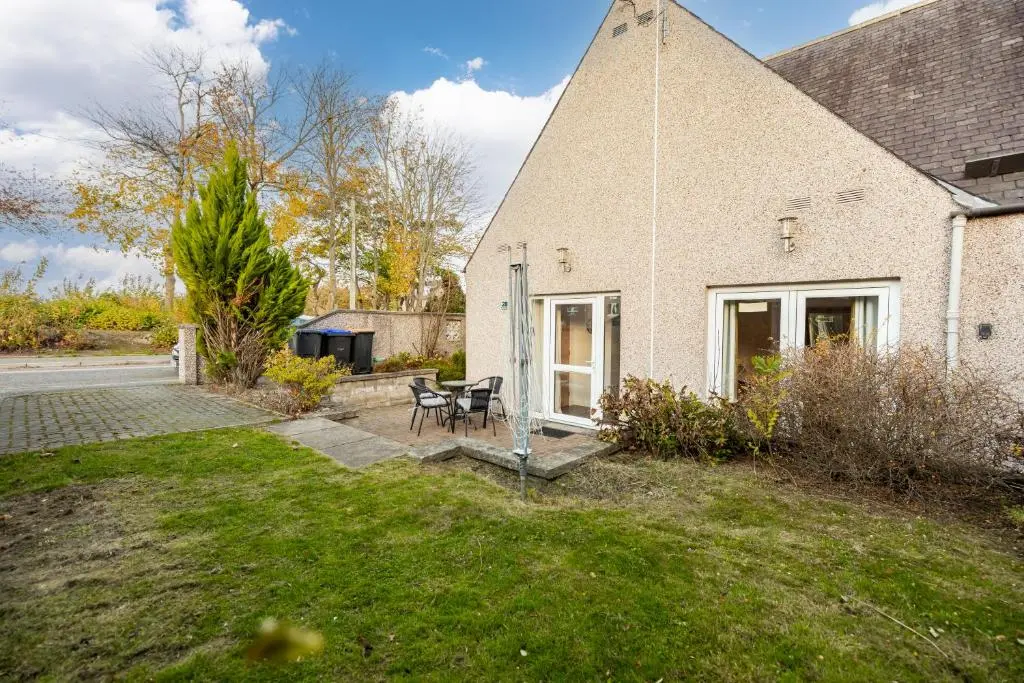 a brick house with a patio and a yard at Bright House with Garden & Patio in Market Town in Inverurie