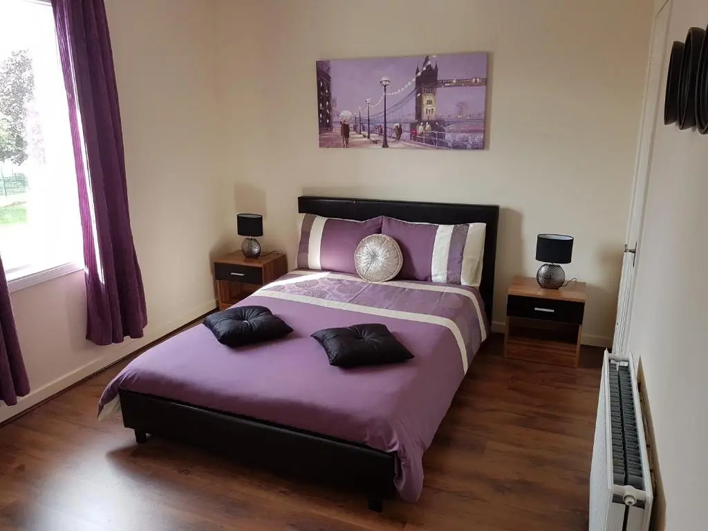 a bedroom with a purple bed with two pillows on it at Spacious 2 double bedrooms house for a relaxing stay. in Inverness