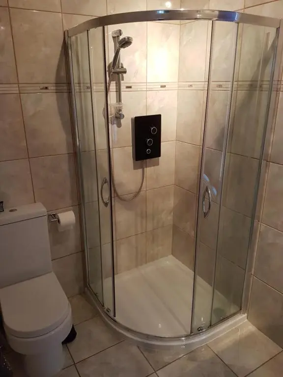 a shower stall in a bathroom with a toilet at Spacious 2 double bedrooms house for a relaxing stay. in Inverness