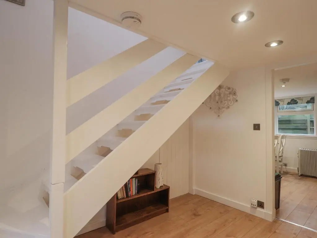 a white staircase in a living room with a book shelf at 3 Dunrobin Street in Tain