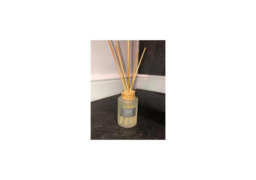 a vase with bamboo sticks in it at Grey Apartment in Inverness
