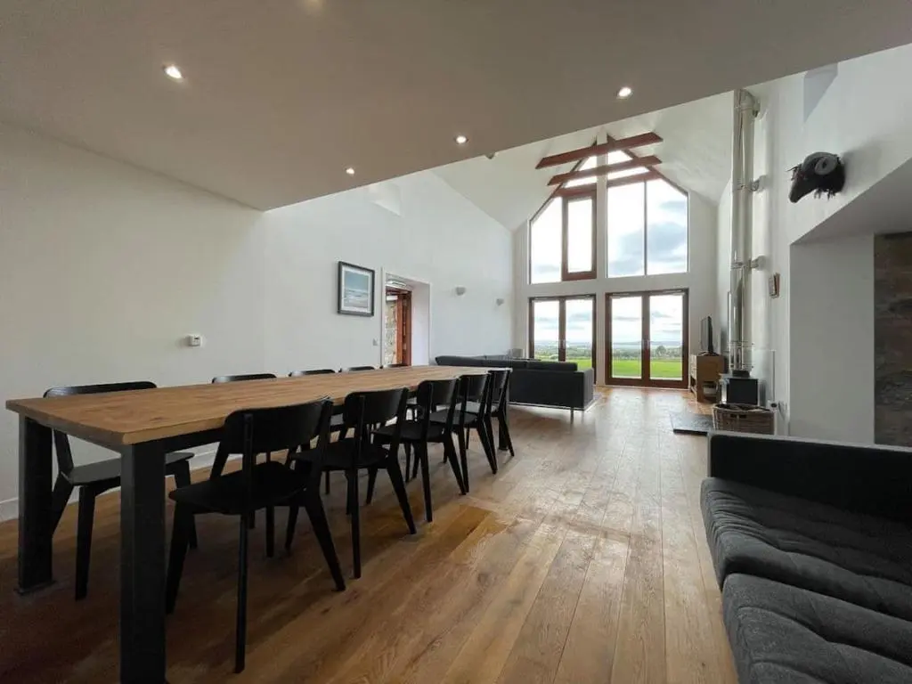 a large dining room with a table and chairs at Balloan Steading East in Dornoch