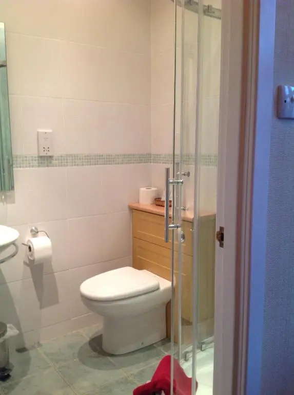 a bathroom with a toilet and a glass shower at Moraydale Guest House in Elgin