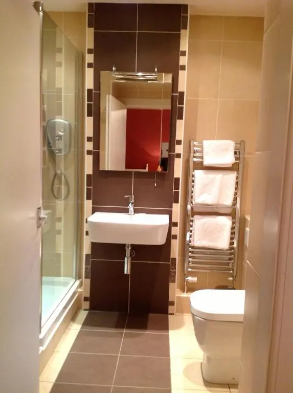a bathroom with a sink and a toilet and a mirror at Moraydale Guest House in Elgin