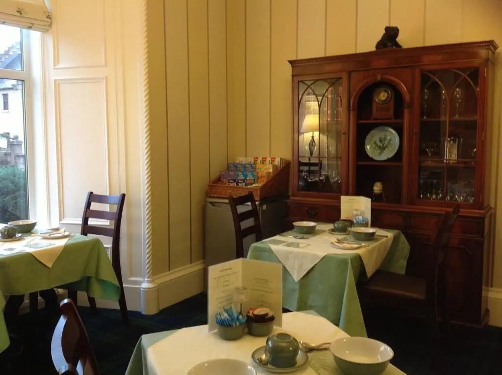 a dining room with two tables and a clock at Moraydale Guest House in Elgin